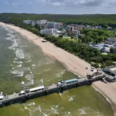 Molo i plaża w kurorcie nadmorskim. Idealne miejsce na jednodniowe wycieczki zachodniopomorskie, z hotelami i lasem w tle.