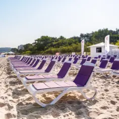 Wczasy dla seniora nad morzem z wyżywieniem: rzędy leżaków na piaszczystej plaży, gotowe na relaks.