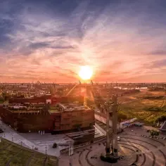 Zachód słońca nad placem Solidarności w Gdańsku. Monumentalne krzyże i nowoczesna architektura w blasku złotej godziny.
