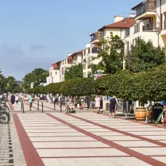 Promenada w Świnoujściu tętni życiem. Spacerowicze, rowery i kawiarniane stoliki tworzą urokliwe promenada świnoujście atrakcje.