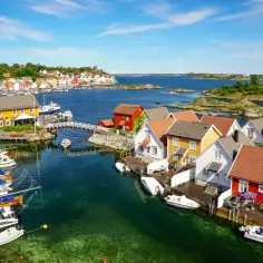 Malowniczy port z kolorowymi domkami i łodziami. Widok ten pokazuje, że Norwegia ma dostęp do morza, choć nie do Bałtyku.