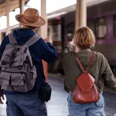 Para, plecak i walizka czekają na pociąg nad morze.