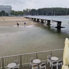 Spacerem po plaży, gdzie widać, kiedy przypływ kiedy odpływ. W oddali hotel i molo.