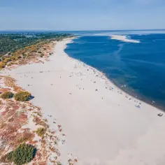 Piękna plaża z turkusowym morzem i zielonym lasem. Idealne miejsce, gdzie nad morze we wrześniu, by cieszyć się słońcem i spokojem.